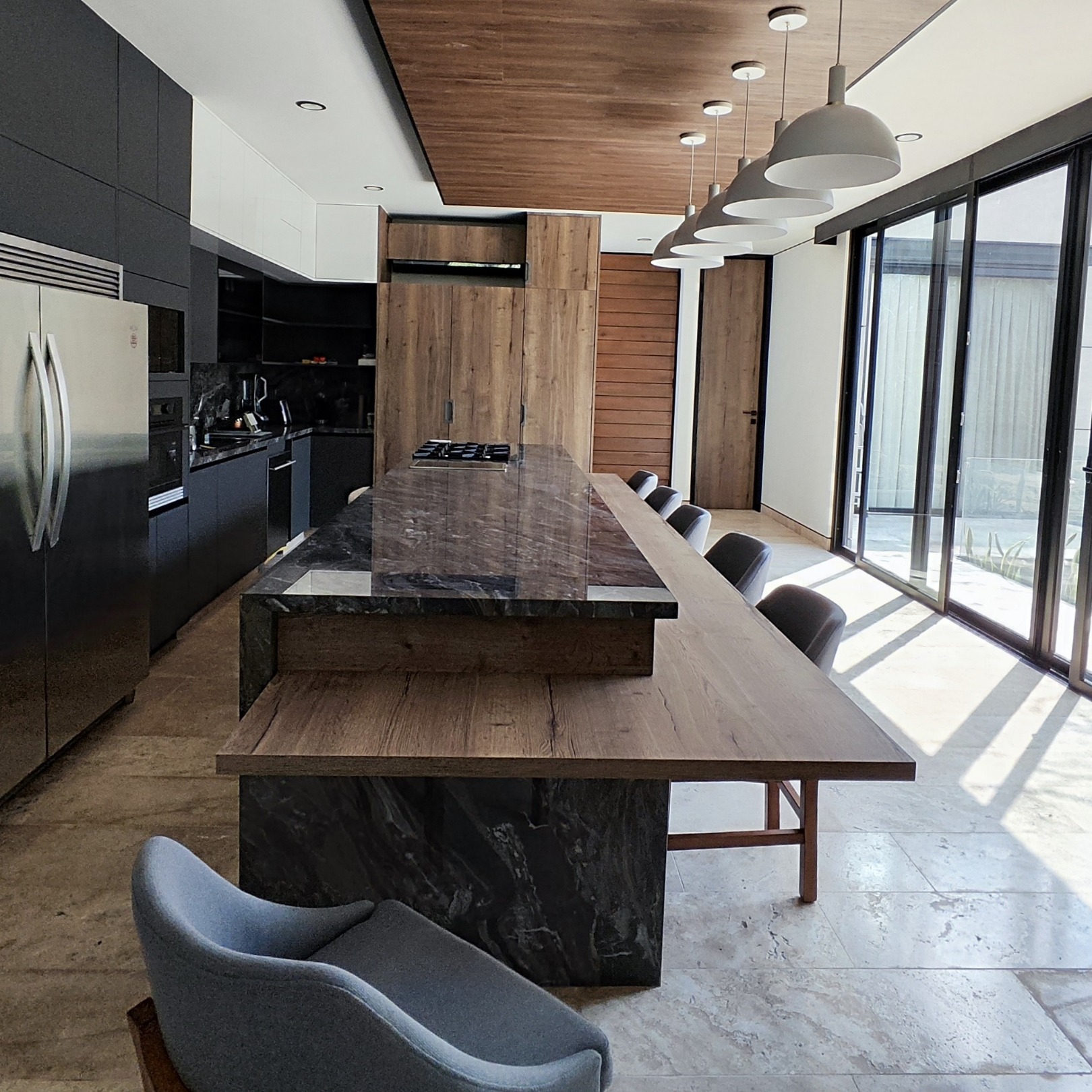Cocina amplia Novecci con madera oscura y ventanales