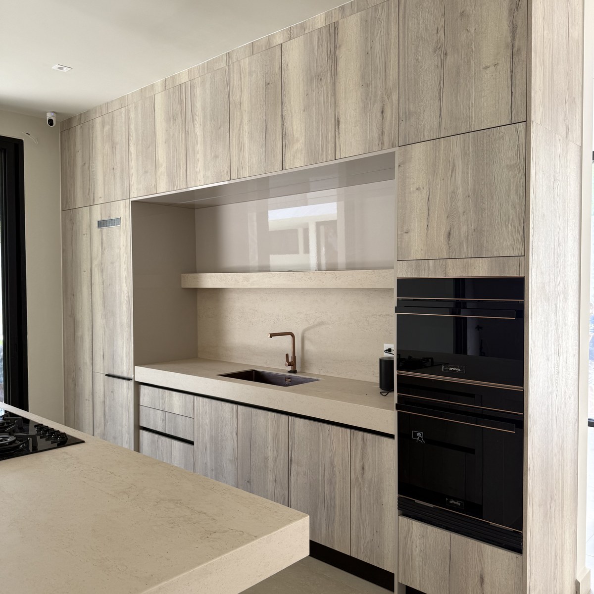 Cocina Novecci gris con mobiliario integrado y electrodomésticos empotrados