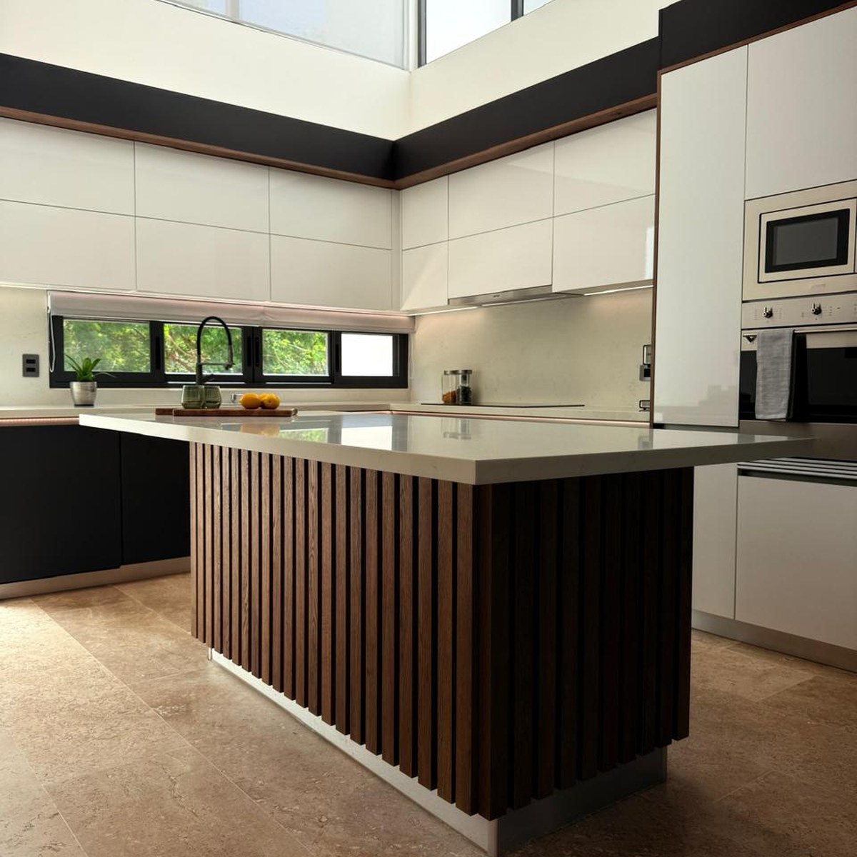 Cocina Novecci de doble altura con isla de madera acanalada